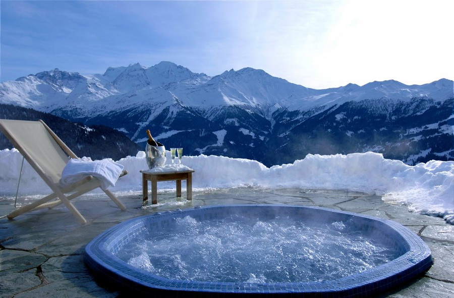Милашка стоит в джакузи под открытым небом в Альпах